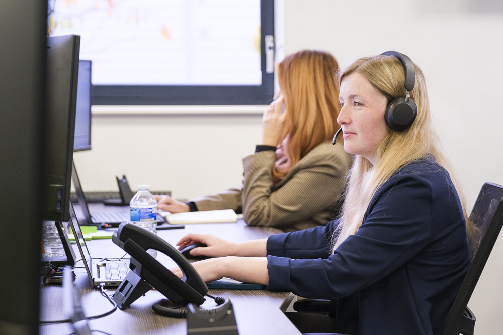 Lady speaking on desktop phone.