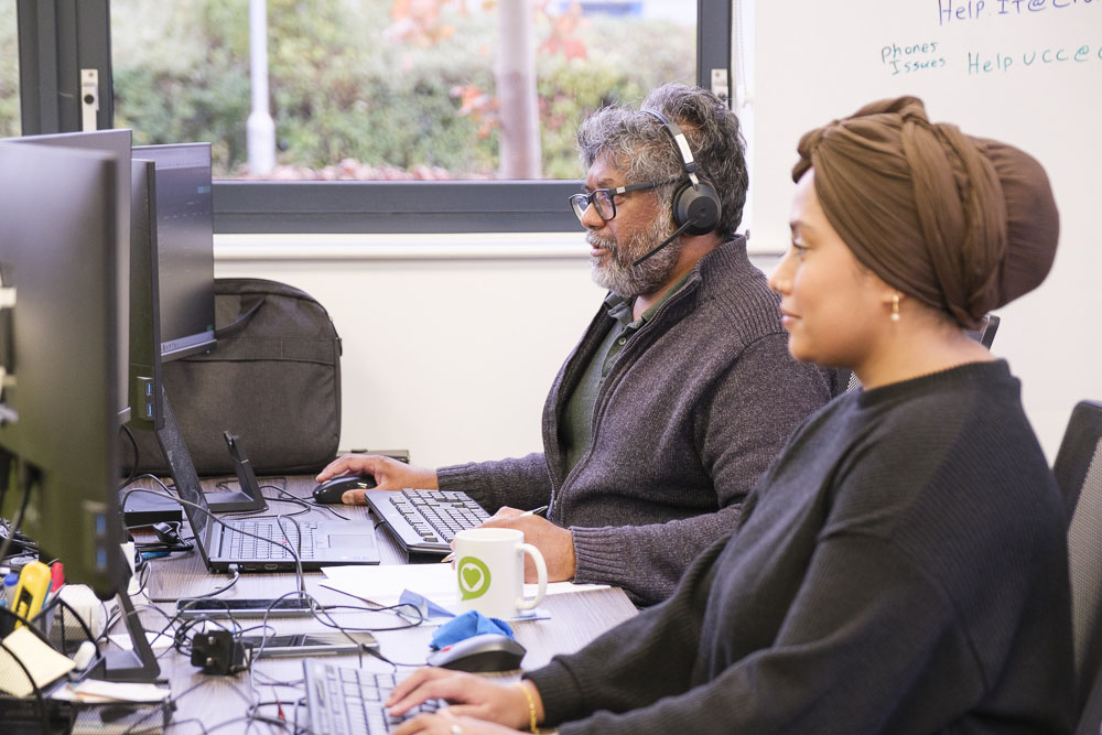 Two employees working at desktop PCs supported by Croft's Modern Workplace solution.