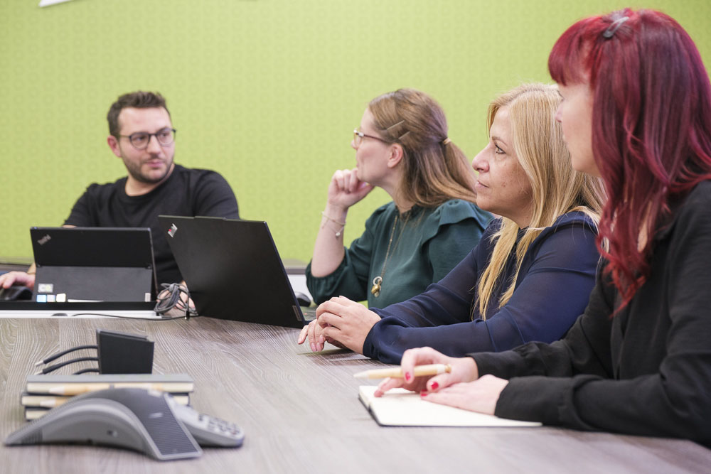 Croft employees sitting in the Hertford head office meeting table discussing our client hub