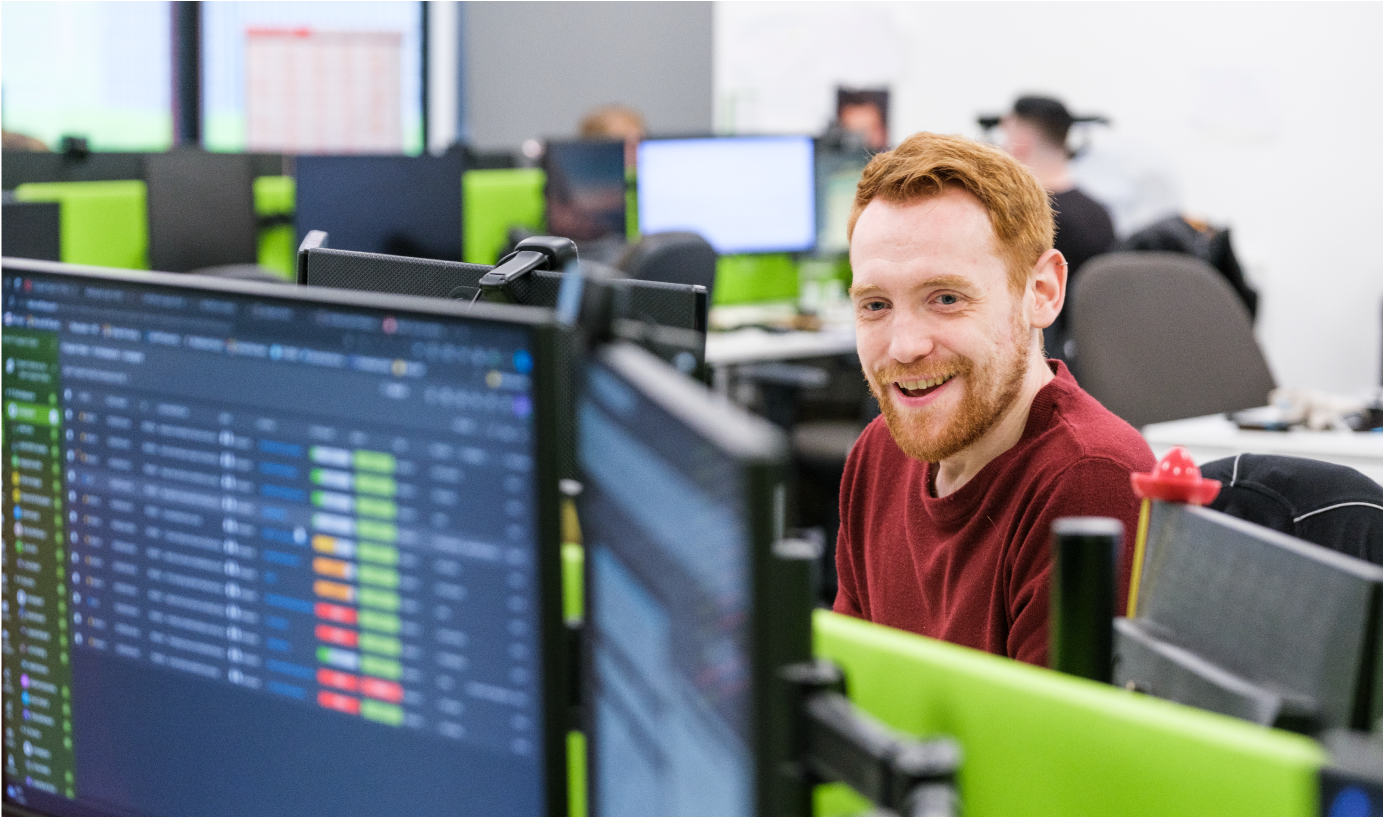 Cyber security expert wearing a red shirt working at a desktop PC.