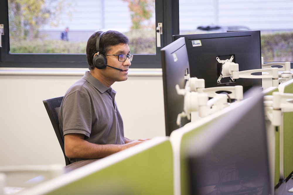 Croft 3CX engineer working at a PC while talking on a desktop phone