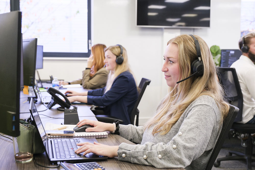 Croft voice services expert talking on a desktop phone while working on a computer