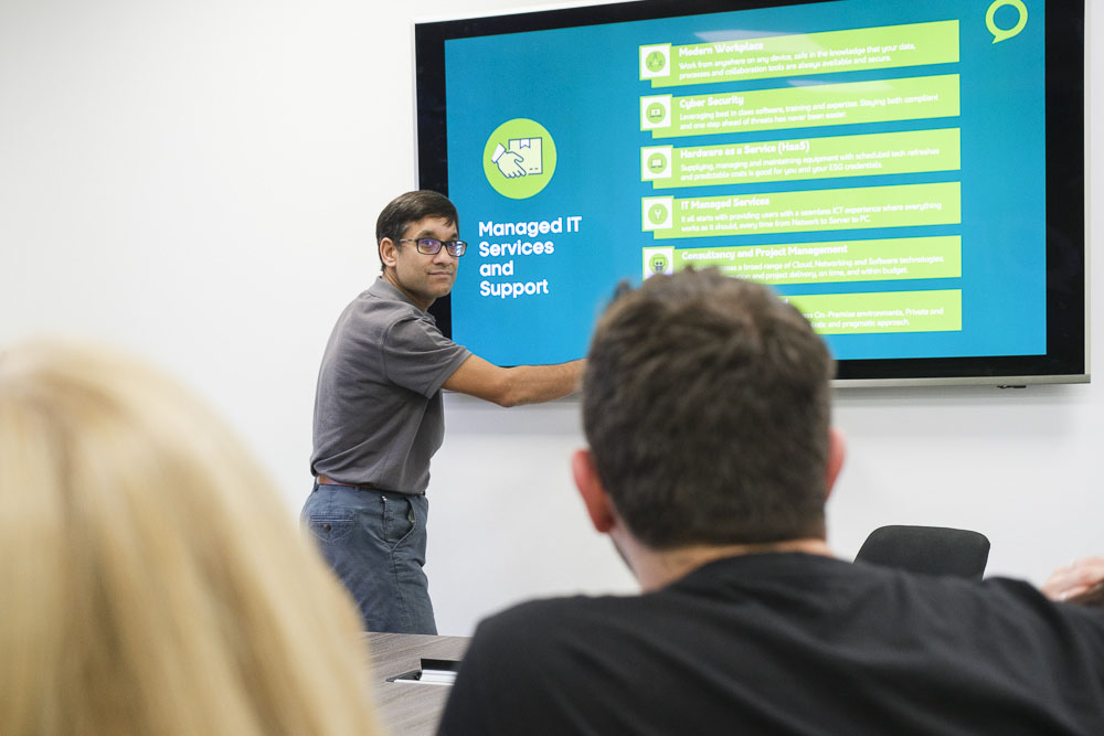 Croft meet the team employee presenting a PowerPoint on a big screen in our Hertford office meeting room.