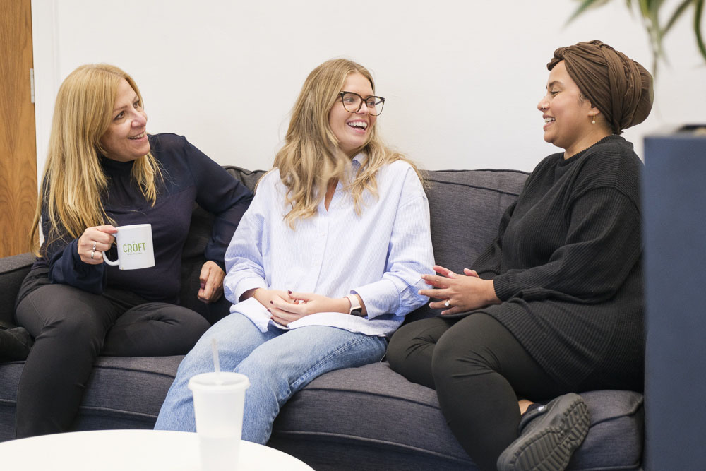 Croft meet the team employees chatting over a cup of tea on our grey office sofa.