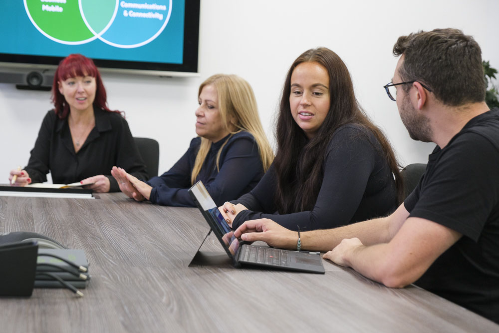 Croft meet the team employees meeting at our Hartford office with their laptops.