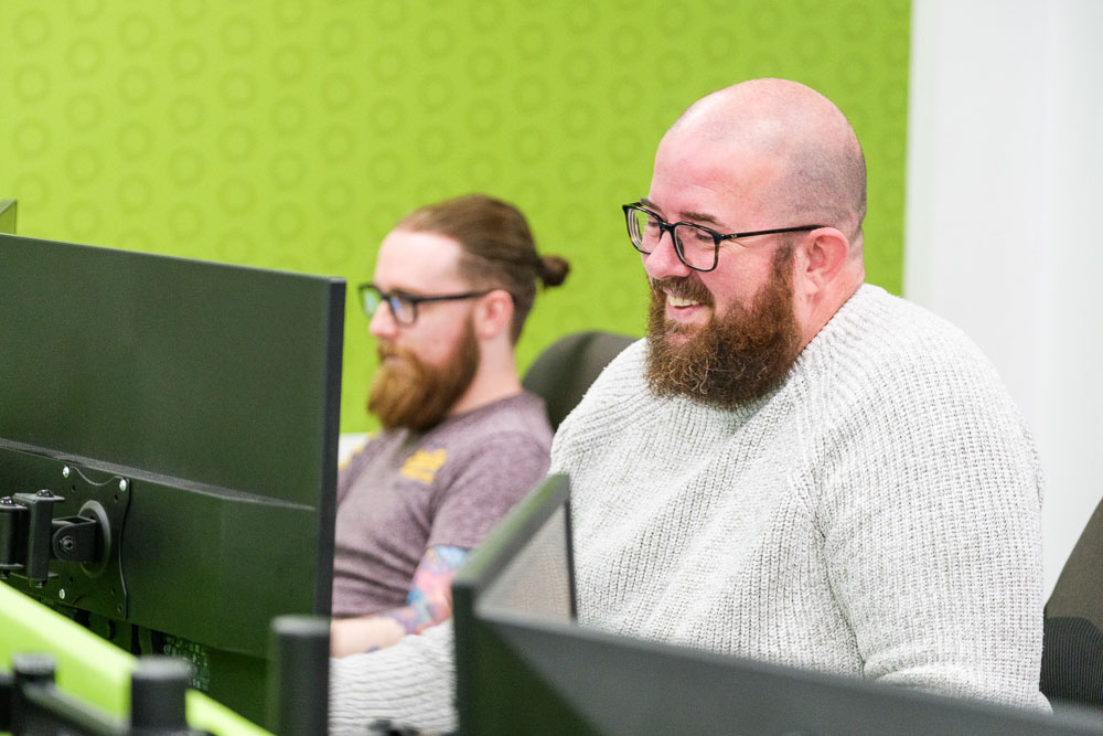 Croft meet the team - two employees at our Midlands office working at desktop computers