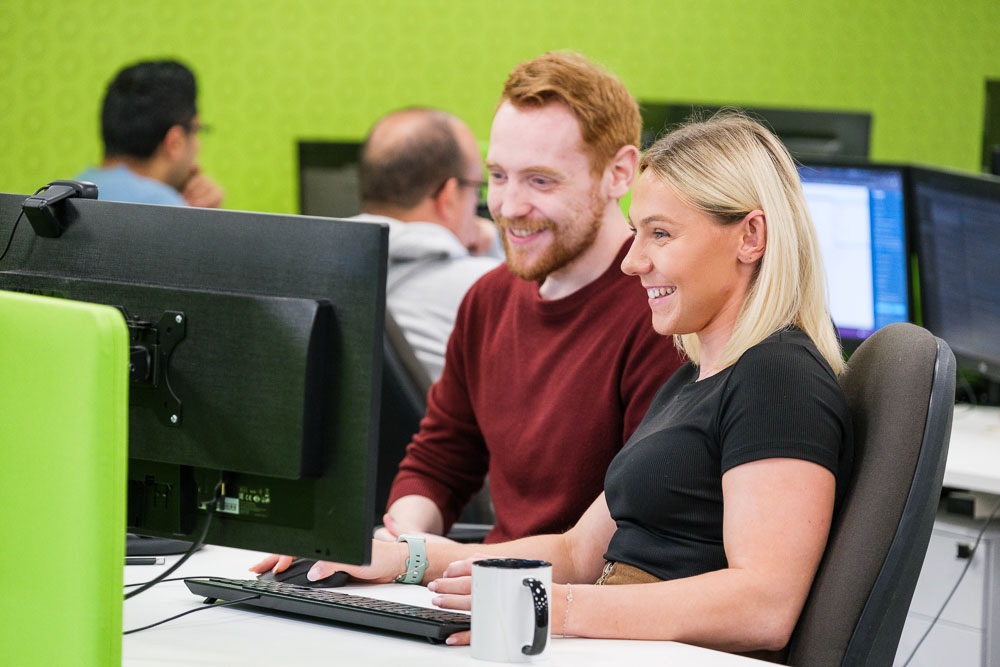 Croft meet the team employees working together at a desktop computer in our Midlands office.